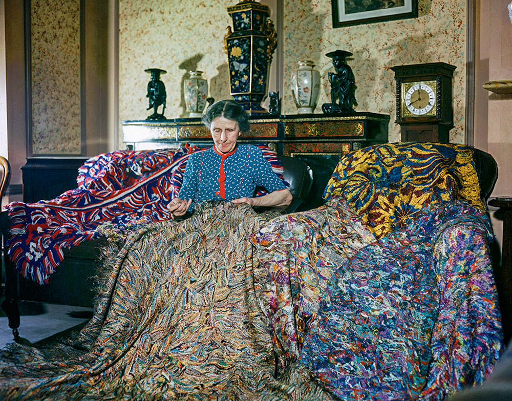 L’artista anglesa Madge Gill (Maude Ethel Eades) realitzant una manta amb fils de seda inserits en una lona, 19 d’agost de 1947. La manta conté al menys dos millions de puntades i és el resultat de sis mesos de treball.